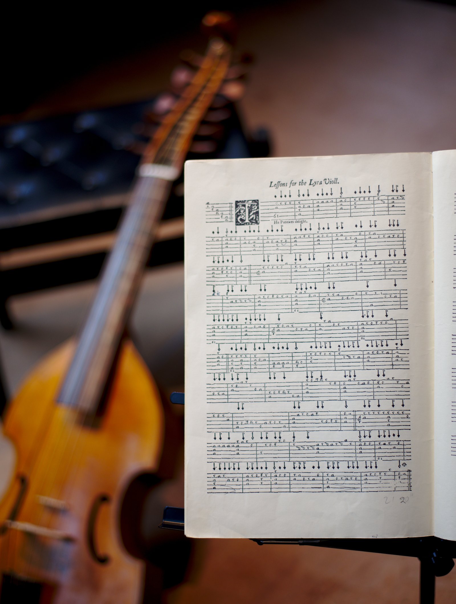 Viola da gamba beside a music stand with Lessons for the Lyra Viol, opened at The Puncke's Delight