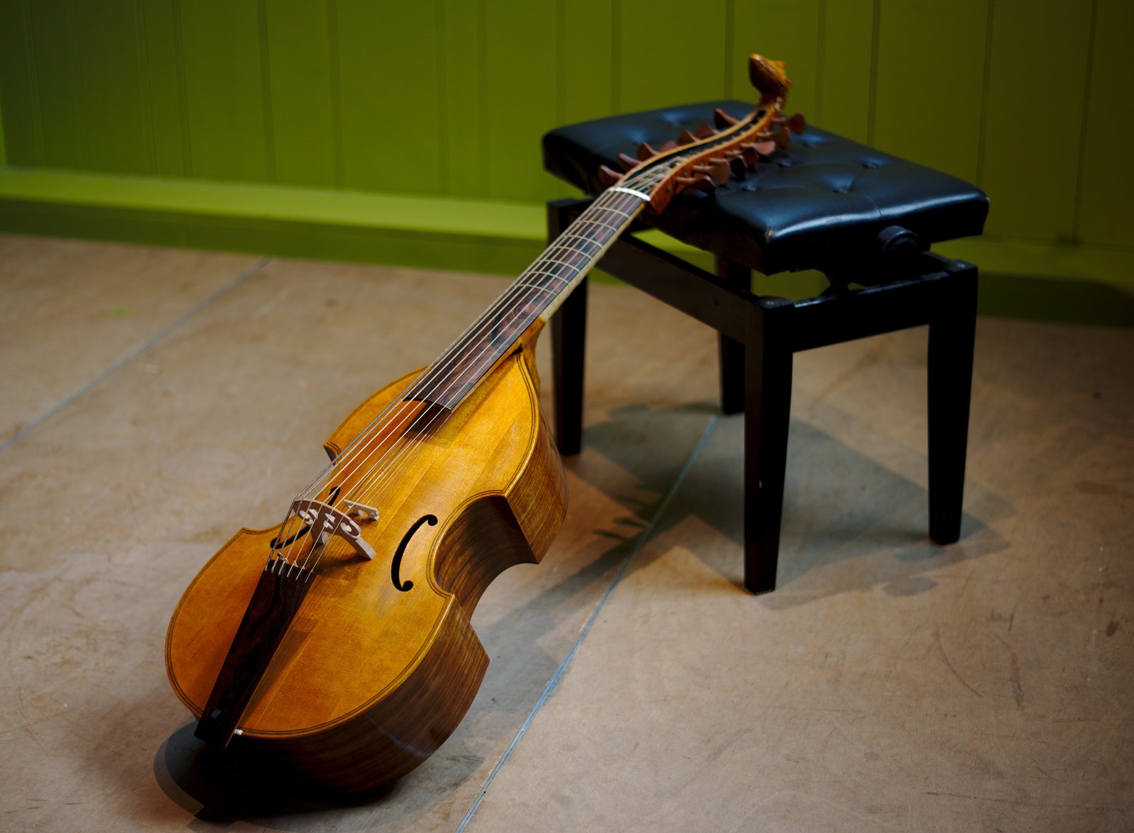 Viola da gamba resting on a piano stool
